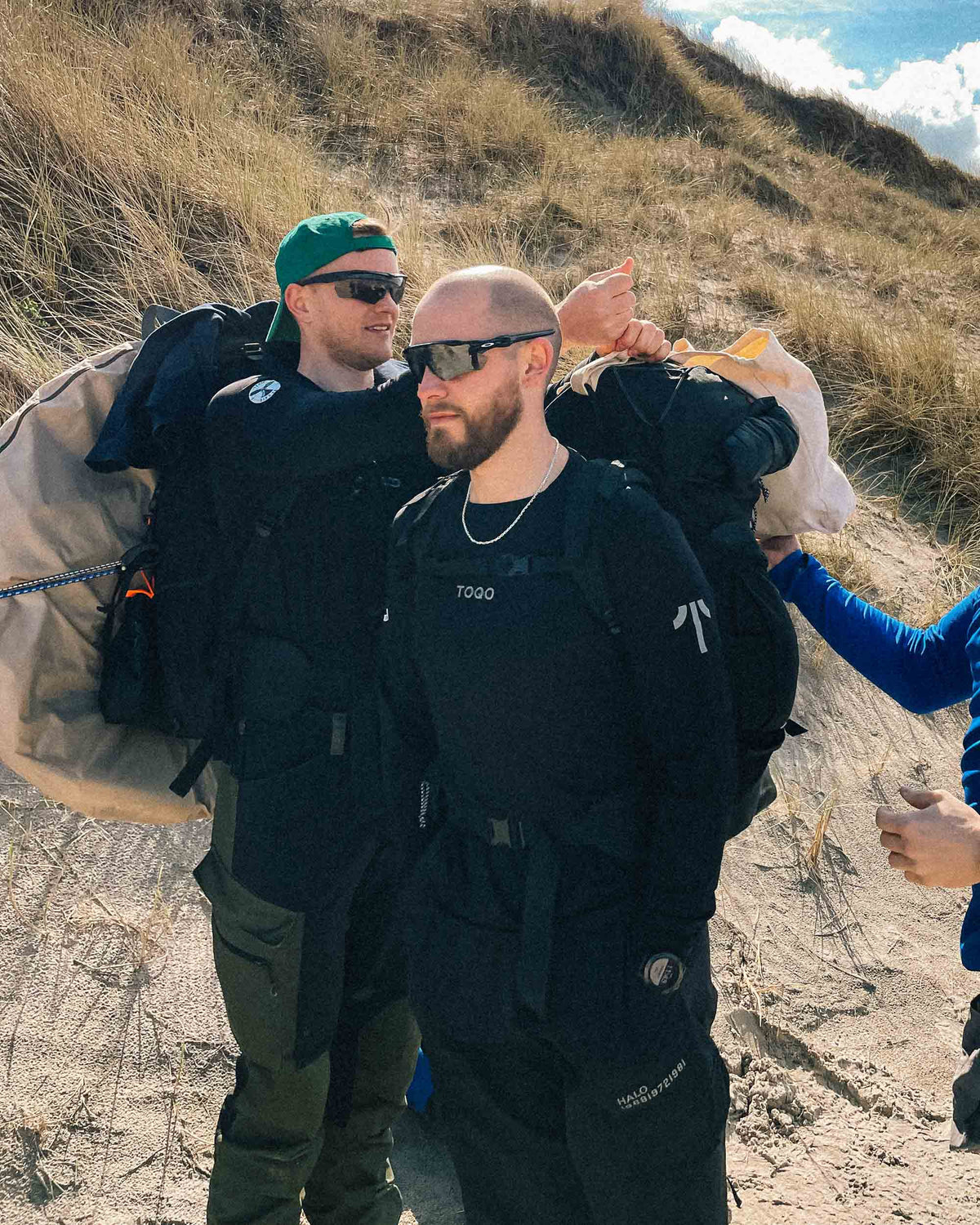 Two guys standing at a beach in TOQO shirts
